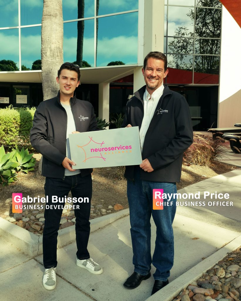 Gabriel Buisson and Raymond Price holding the NEuroservices-Alliance sign